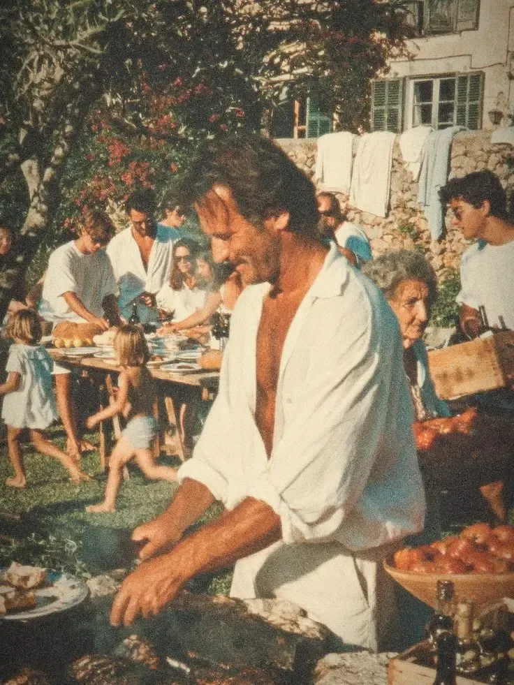 Un homme fait griller la viande lors d'un déjeuner de famille en plein air, restaurée